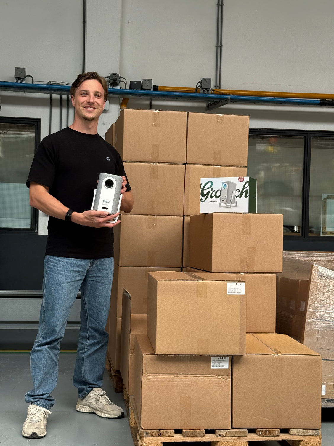 Dion van Lumenix met een Grolsch x Lumenix-beamer bij de pallets voor Grolsch