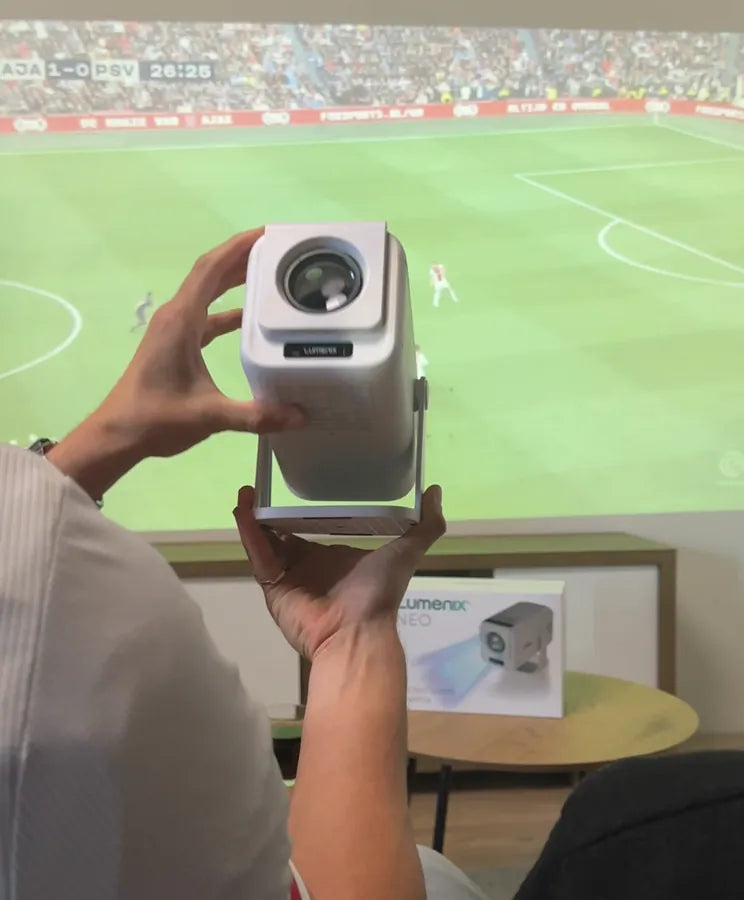 Een witte NEO in de hand, voor een voetbalwedstrijd op de muur