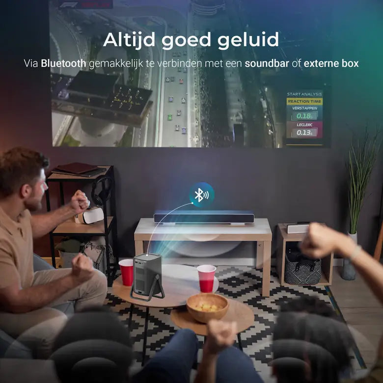 Vrienden kijken samen naar het grote beeld van de Lumenix AIR zwart, met een soundbar via Bluetooth