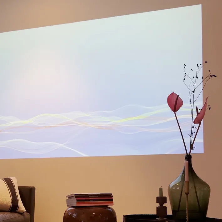 Na: dezelfde woonkamer met een groot beeld van de NEO op de muur